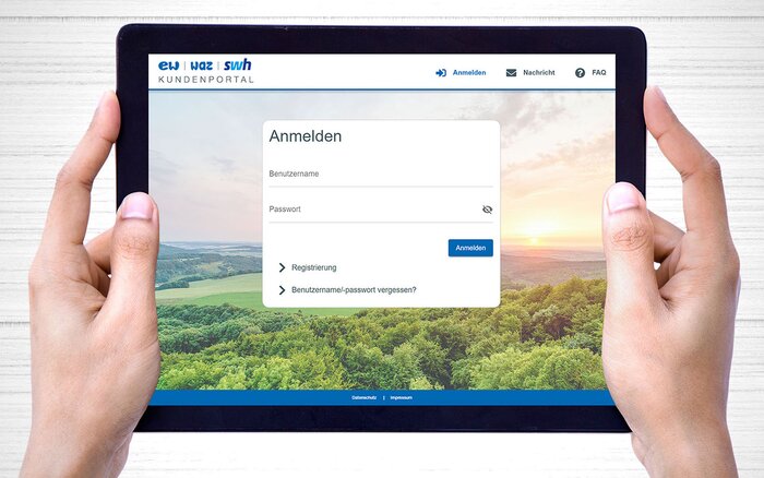 Tablet mit Login-Seite eines Kundenportals, gehalten von zwei Händen.