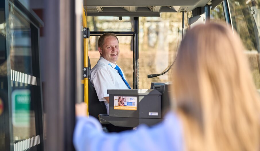 Person steigt in Bus ein, Fahrer vorne sichtbar