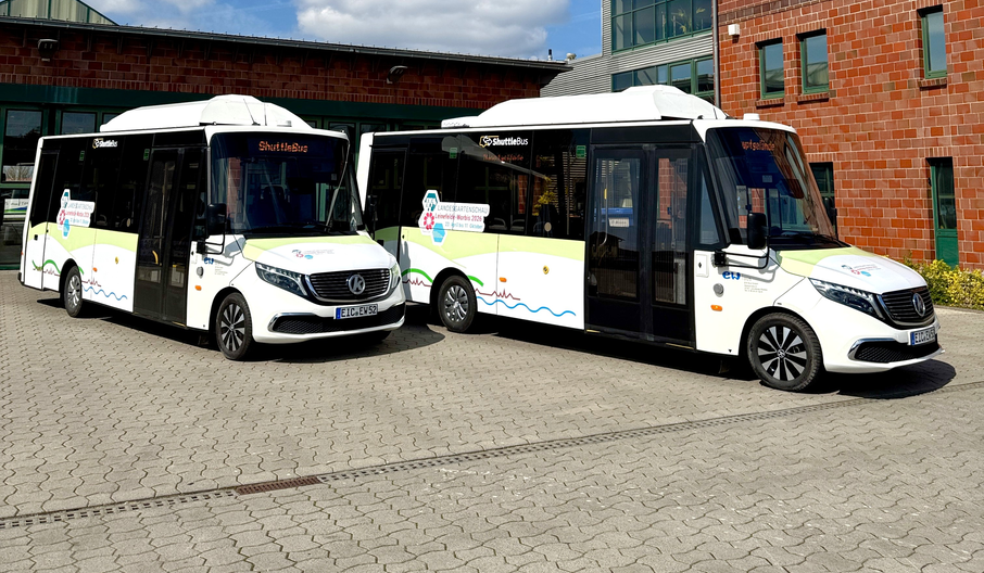 2 weiße Shuttle-Busse der EW Bus mit dem Logo der Landesgartenschaun stehen auf dem Gelände der EW Bus in Leinefelde.