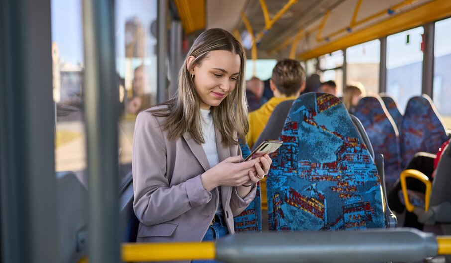 Person mit Smartphone im Bus