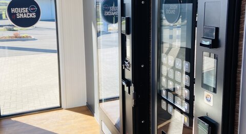 Zwei moderne Verkaufsautomaten für Snacks und Getränke mit digitalen Bedien- und Bezahlmöglichkeiten.