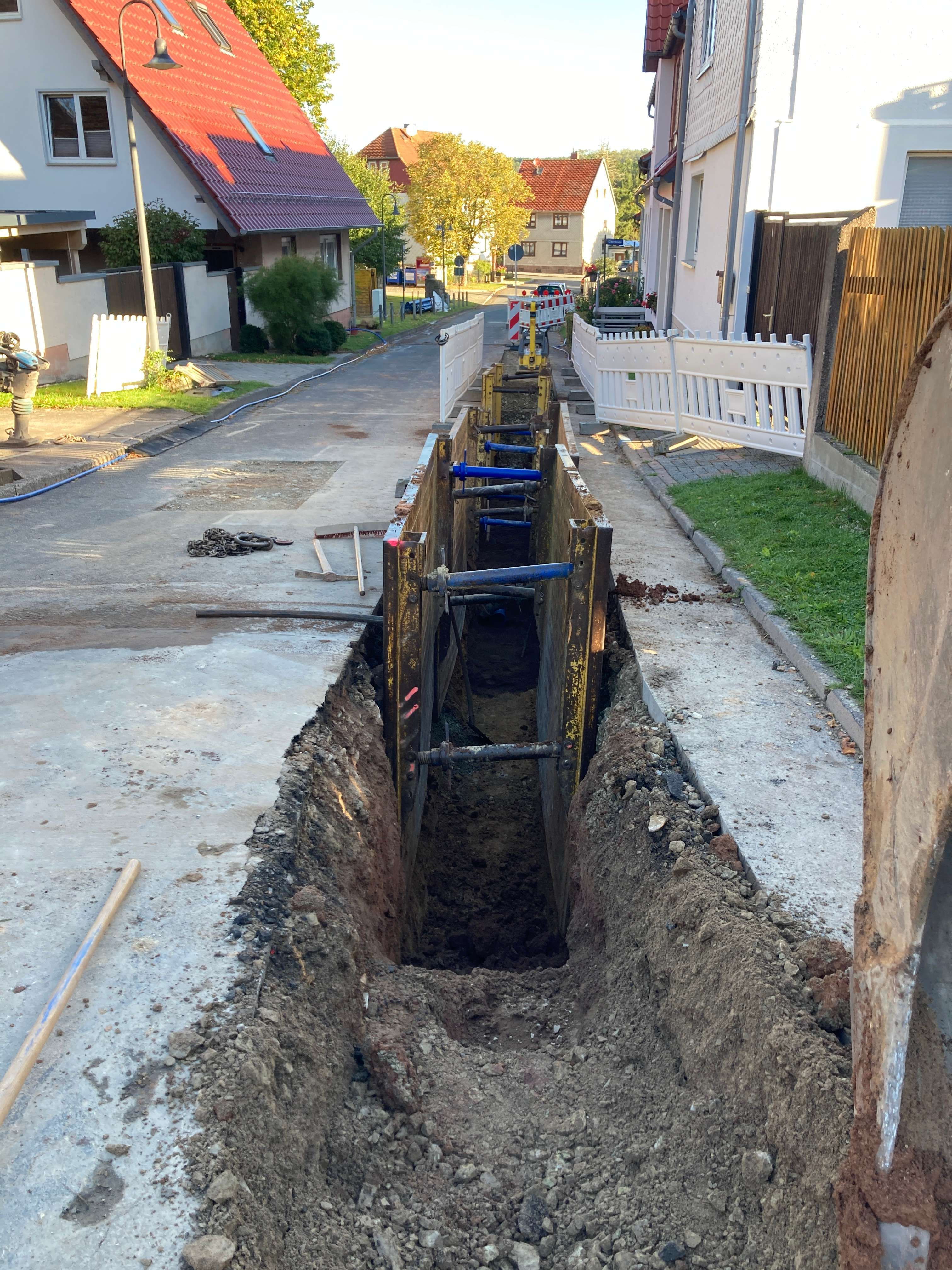 Ein tiefer, schmaler Graben, der mit großen Verbauplatten gesichert ist.