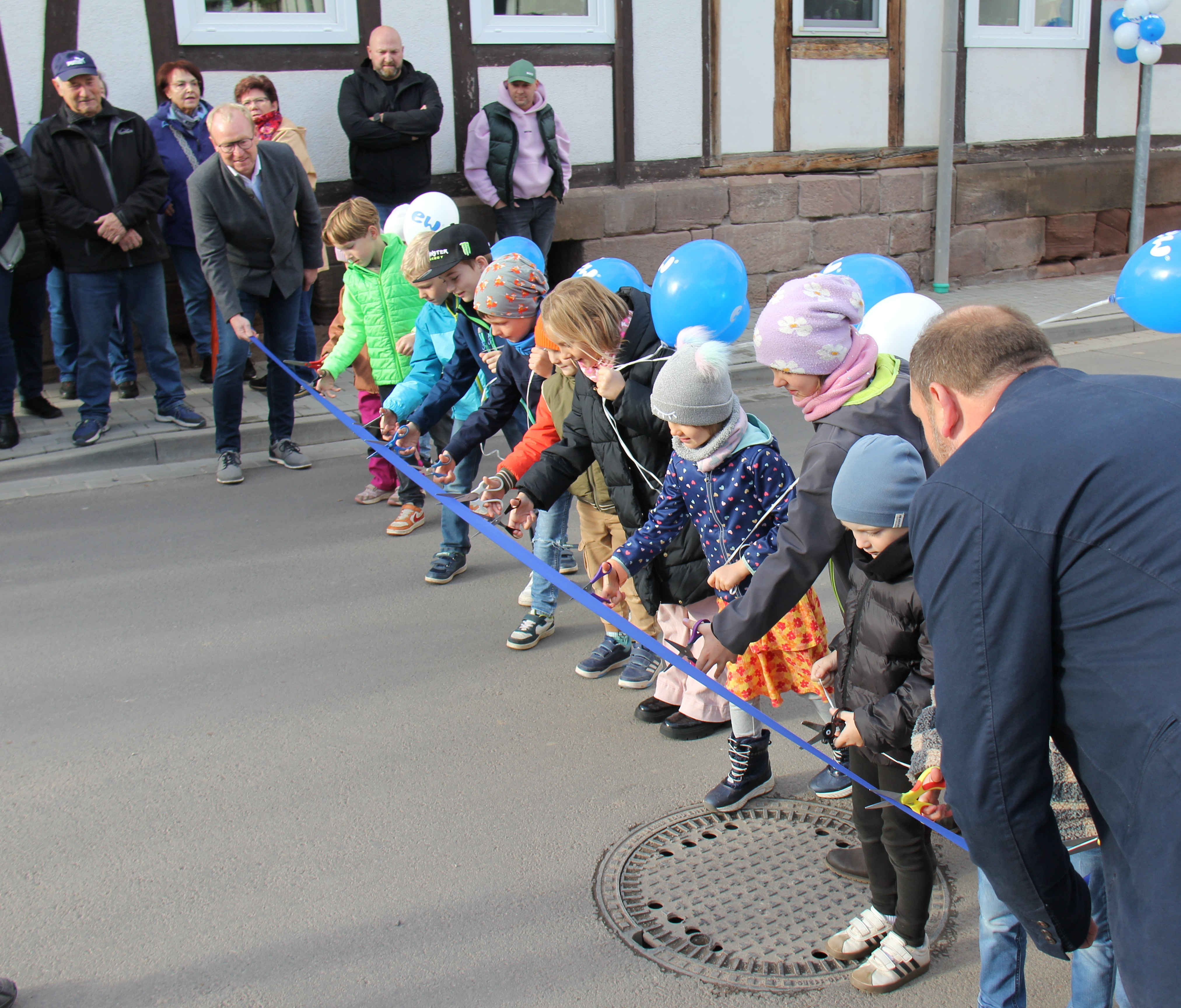 Kinder nach vorn: Bei der offiziellen Eröffnung des jüngsten Bauabschnitts in Arenshausen in der Thomas-Müntzer-Straße hielten Adrian Grieß, Verbandsvorsitzender des WAZ Obereichsfeld, und Arenshausens Bürgermeister Matthias Geyer das Band. Den symbolischen Schnitt übernahmen die Jungen und Mädchen aus der Ortschaft am 24. Oktober 2025.